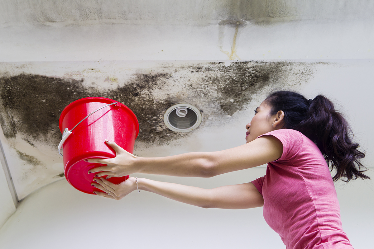 Young woman collecting drops rainwater
